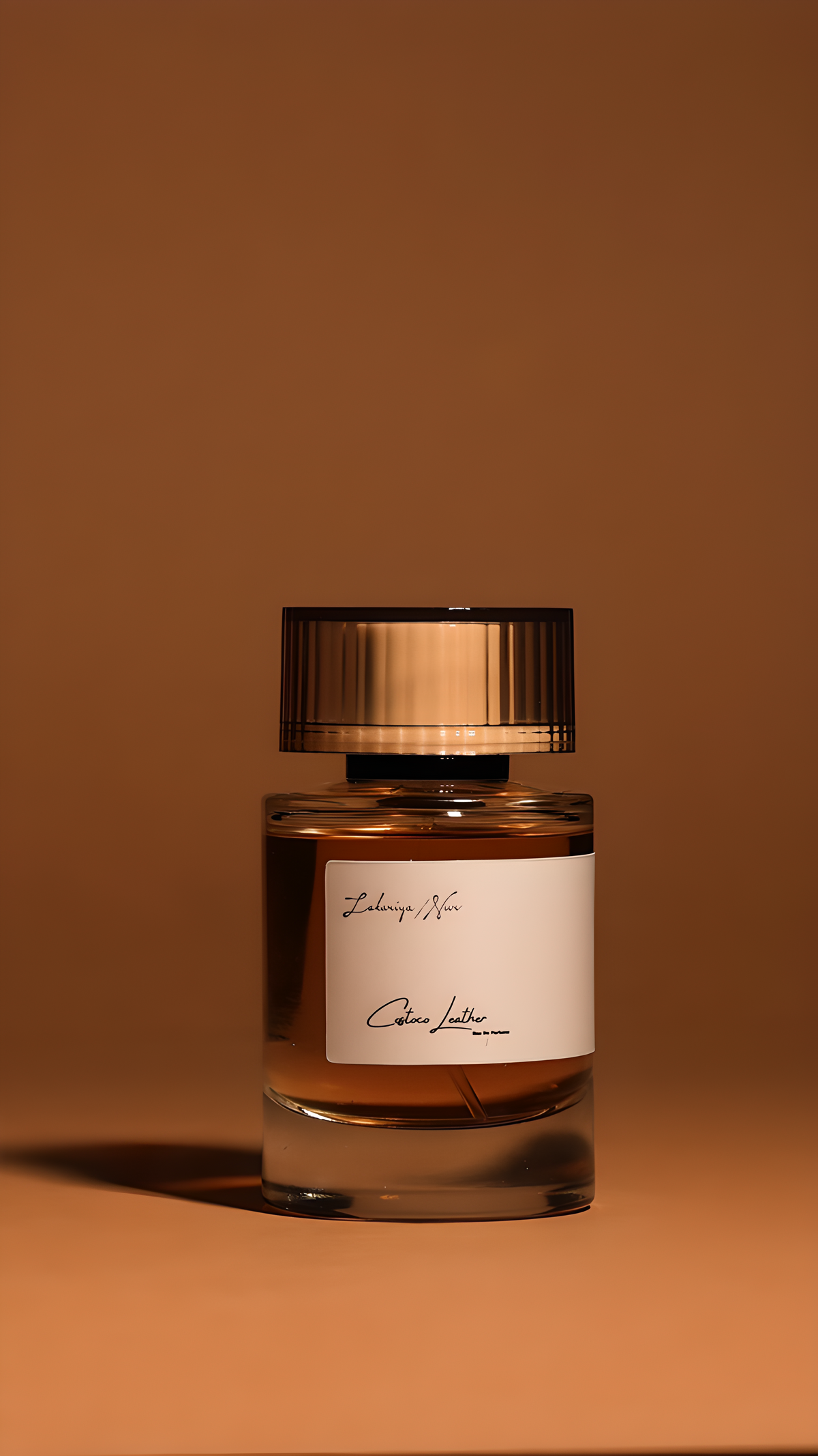 Perfume bottle with a gold cap and clear glass body on a brown background